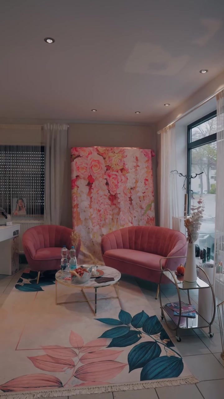 Lounge-Bereich mit rosa Samtsofas und Blumenwand
